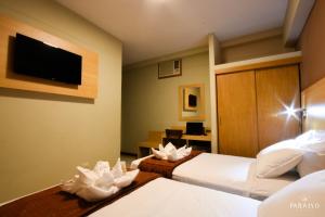 Hoteles Paraiso CHICLAYO في تشيكلايو: غرفة فندقية بسريرين وتلفزيون بشاشة مسطحة