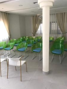 a room with green chairs and a column at Hotel Bel Azur Cotonou in Cotonou
