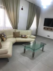 sala de estar con sofá y mesa de centro de cristal en Hotel Bel Azur Cotonou, en Cotonou