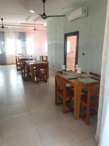 een eetkamer met houten tafels en stoelen bij Hotel Bel Azur Cotonou in Cotonou