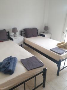Dos camas en una habitación con toallas. en Konstantinos Apartmend Halkidiki, en Sozopoli