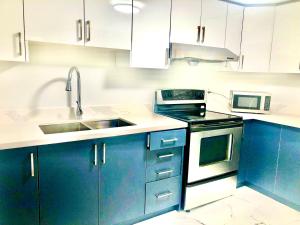 a kitchen with blue cabinets and a sink at CozyHome in Markham