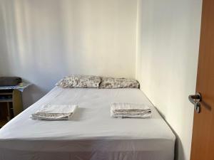 Bett in einem Zimmer mit zwei Kissen darauf in der Unterkunft Flat com boa localização in Palmas
