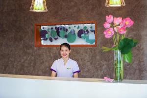 a woman standing in front of a mirror at ÊMM Hotel Hue in Hue