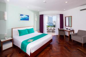 Habitación de hotel con cama y silla en ÊMM Hotel Hue en Hue