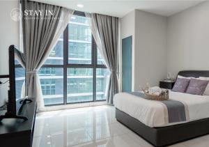 1 dormitorio con cama y ventana grande en Atria Sofo Suites - Petaling Jaya, en Petaling Jaya