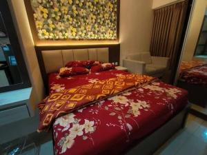 a bedroom with a bed with a red comforter at Apartment Mont Blanc By Ilfal in Bekasi