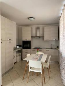 cocina con mesa blanca y sillas blancas en Casa Magenta Apartment 1, en Valeggio sul Mincio