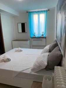 a bedroom with a large white bed with a blue window at Casa Magenta Apartment 1 in Valeggio sul Mincio
