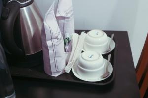 a black table with two cups and chopsticks at Edens Munnar in Munnar