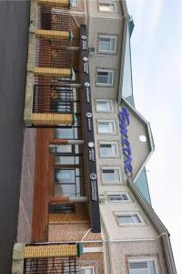 a tall building with a sign on the side of it at Hotel Bahetle in Ekibastuz