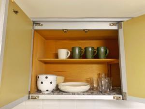a cupboard with bowls and other dishes in it at Wayado Sapporo Ciao in Sapporo