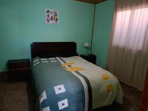 Dormitorio con cama con colcha y cruces. en Casa VillaOliva en Luján de Cuyo