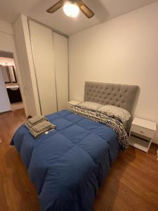 una camera da letto con un grande letto con una coperta blu di Dos ambientes en Caballito a Buenos Aires