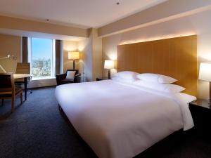 a large white bed in a hotel room at Sheraton Miyako Hotel Osaka in Osaka