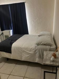 a bed with white sheets and a table in a room at Hollywood Beach 3 Bedroom Apartment in Hollywood
