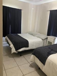 a bedroom with two beds with black and white sheets at Hollywood Beach 3 Bedroom Apartment in Hollywood