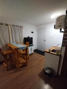 Habitación pequeña con mesa, sillas y cocina. en Monoambiente lindo y luminoso en San Carlos de Bariloche