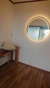Habitación con espejo en la pared y mesa. en Cliff top Terrace, en Kuranomoto