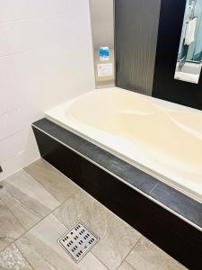 a bath tub in a bathroom with a drain at Asokono Hotel in Kami-seya