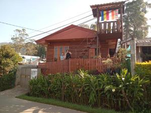 2 personnes debout sur la terrasse couverte d'une maison dans l'établissement 20/20 wood cabana, à Nuwara Eliya