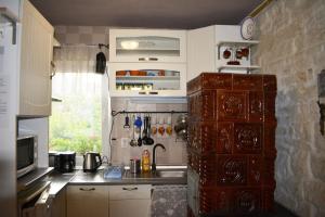 a kitchen with a wooden cabinet and a sink at Stone house next to Cluj-Napoca in Dezmir