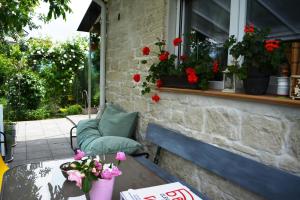 a patio with a table and a window with flowers at Stone house next to Cluj-Napoca in Dezmir