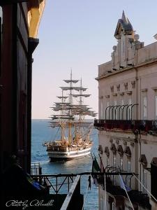 una grande barca a vela nell'acqua accanto agli edifici di B&B Casa Alinella, Happy and Sustainable Hospitality a Taranto