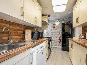 a kitchen with white cabinets and a sink at The Ascot in Blackpool