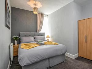 Un dormitorio con una cama con una manta amarilla. en The Ascot, en Blackpool