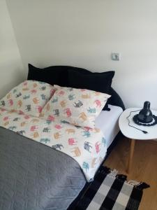 ein Bett mit einem Kissen und einem Beistelltisch in der Unterkunft Martin in Belgrad