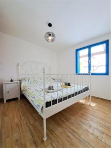 een wit bed in een slaapkamer met een houten vloer bij Villa Robinson in Tkon