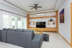 ein Wohnzimmer mit Couch und Flachbildfernseher in der Unterkunft Relax Pool Villa Near Walking Street,jacuzzi ,BBQ 5Bed 6Bath City house54 in Pattaya South
