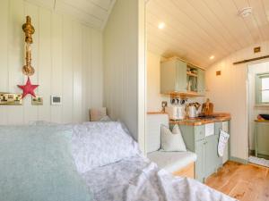 a small bedroom with a bed and a kitchen at Longwool Lookout in Hemingby