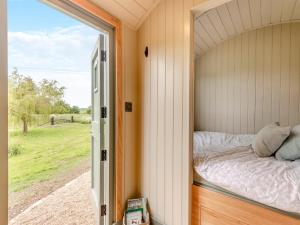 a bed in a small room with a window at Longwool Lookout in Hemingby