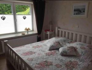 a bedroom with a bed with a quilt and two windows at Ferienwohnung Nähe Altstadt in Sassnitz