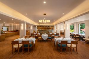 Un comedor con mesas y sillas blancas. en Bookmark Resorts, Manali, en Manali