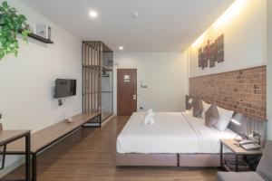 - une chambre avec un lit et un mur en briques dans l'établissement The Old City Wall Inn, à Chiang Mai