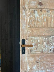 a wooden door with a black door knocker on it at Mareena_apartments in Liepāja