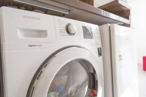 a white washing machine sitting in a room at Belo Exclusivo AP Com Garagem na Cidade Baixa Próximo a Santa Casa, UFRGS e Centro Histórico - BnB Serviços Inteligentes Por Fioravante in Porto Alegre +3 photos