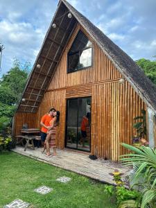 ein Paar steht vor einem Holzhaus in der Unterkunft Don Roberto's Kubo Resort in Nasugbu