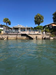 a bridge over a body of water with a house at Absolute waterfront in Raglan