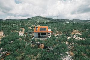 a small house with an orange roof on a hill at Green house in Dograde