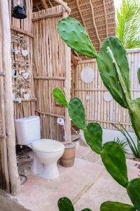 a bathroom with a toilet in a bamboo structure at Le Pirate Island - Adults Only in Labuan Bajo