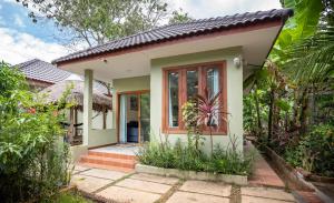 a small house with a pathway leading to the front door at Sanssouci Kep in Kep