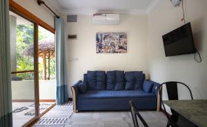 a blue couch in a living room with a tv at Sanssouci Kep in Kep