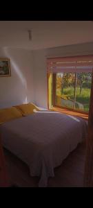 - une chambre avec un grand lit et une fenêtre dans l'établissement Cabañas central Lebu, à Lebu