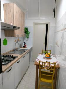 a kitchen with white cabinets and a table with a plate of fruit at Casa Vacanze l' angolo dei Mori in Termini Imerese