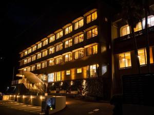 - un grand bâtiment avec des fenêtres éclairées la nuit dans l'établissement SPA-RESORT Ryugunotukai - Vacation STAY 34897v, à Inatori