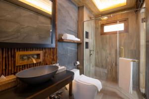 a bathroom with a sink and a shower and a toilet at Sinae Phuket - SHA Extra Plus in Phuket